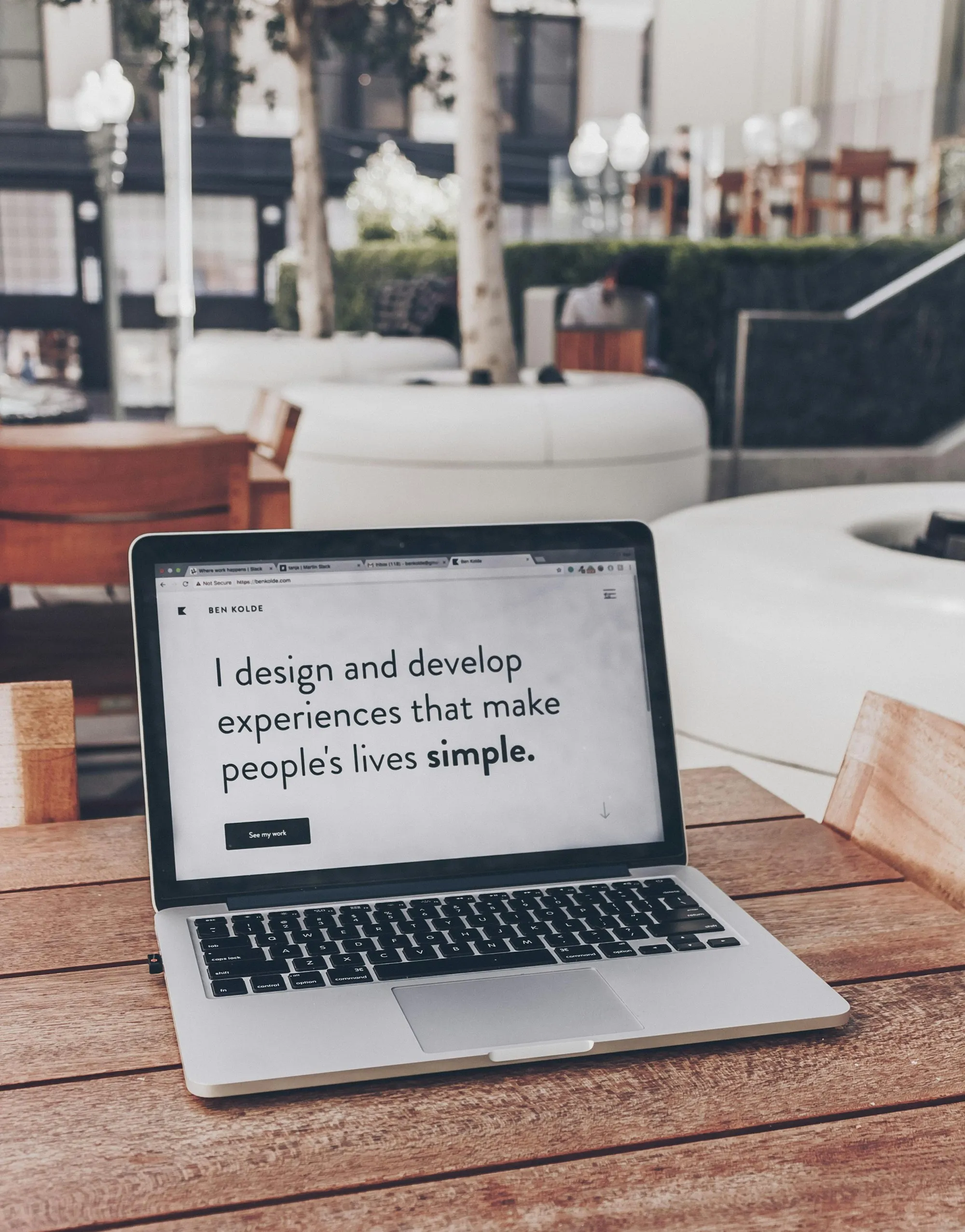 Laptop on a cafe table, open on a design portfolio