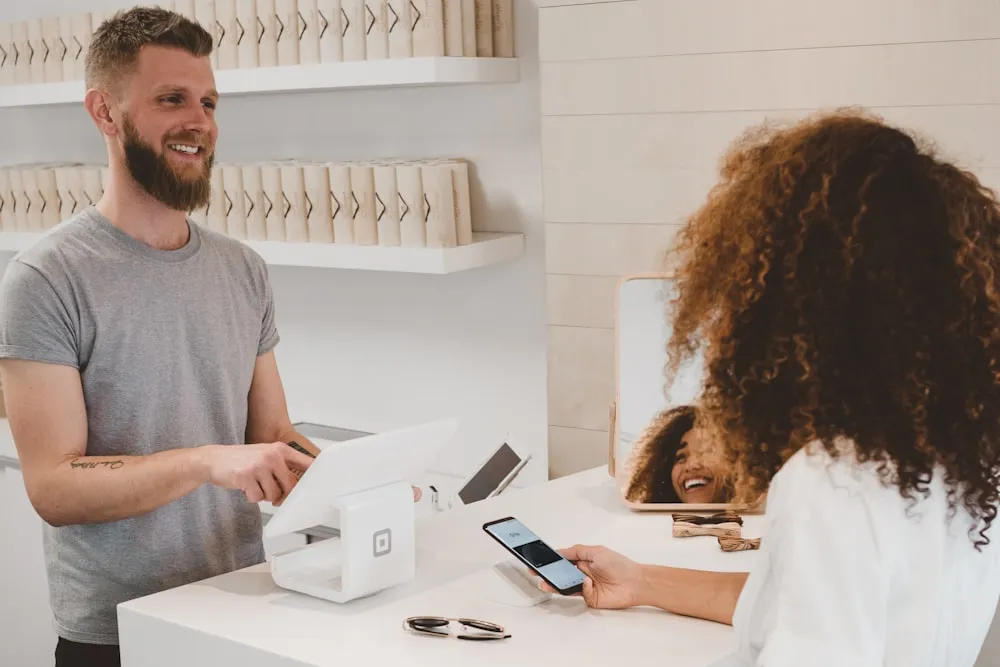 Shopify development: a customer paying by phone at a shop counter